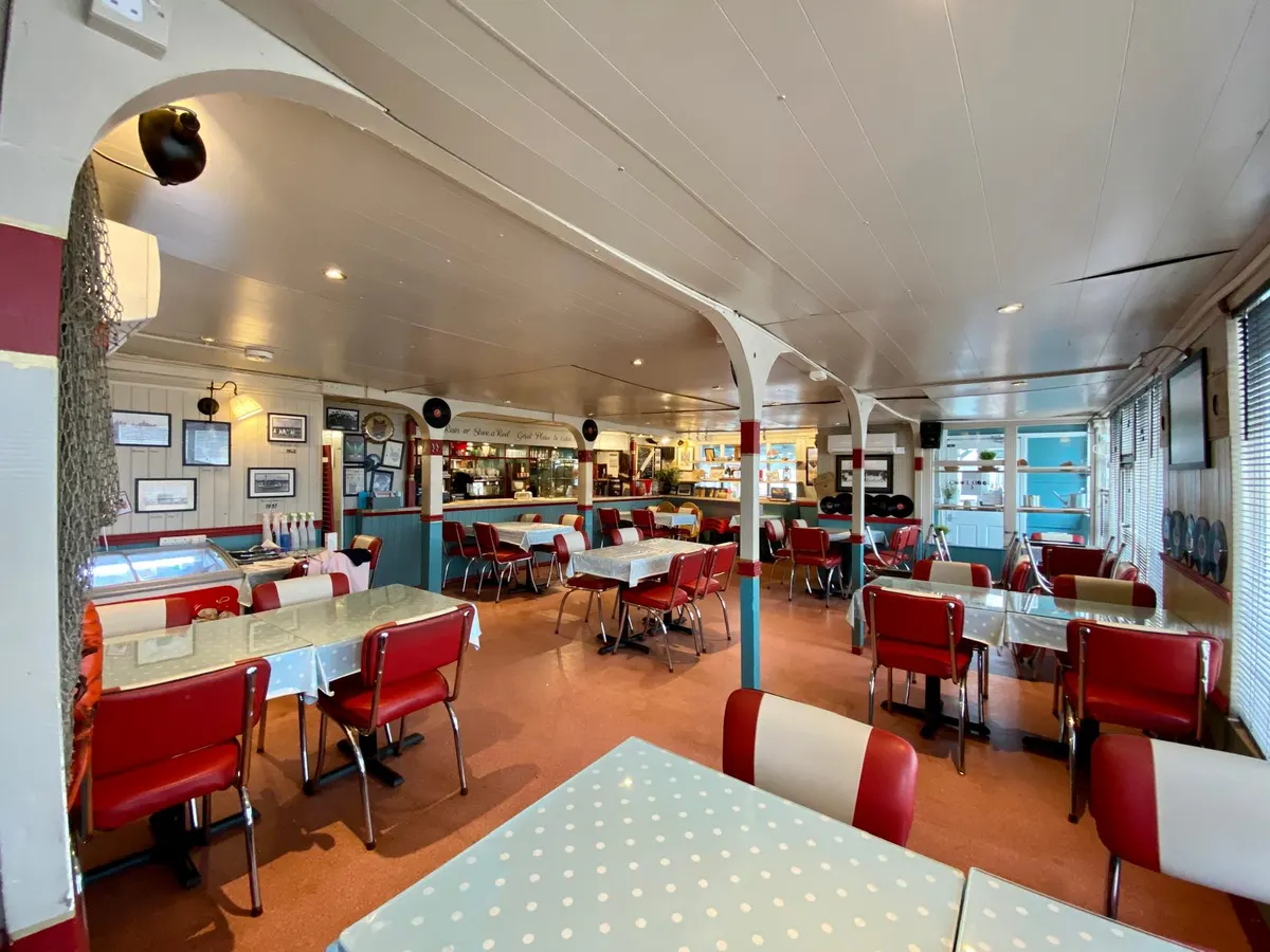 The 1950s American-diner interior at The Ferry Cafe, Felixstowe Ferry, with red leather booths, chrome chairs and vinyl records